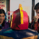 Kamala Khan stares in bemusement as a cheap Captain Marvel costume while her friend Bruno ponders.